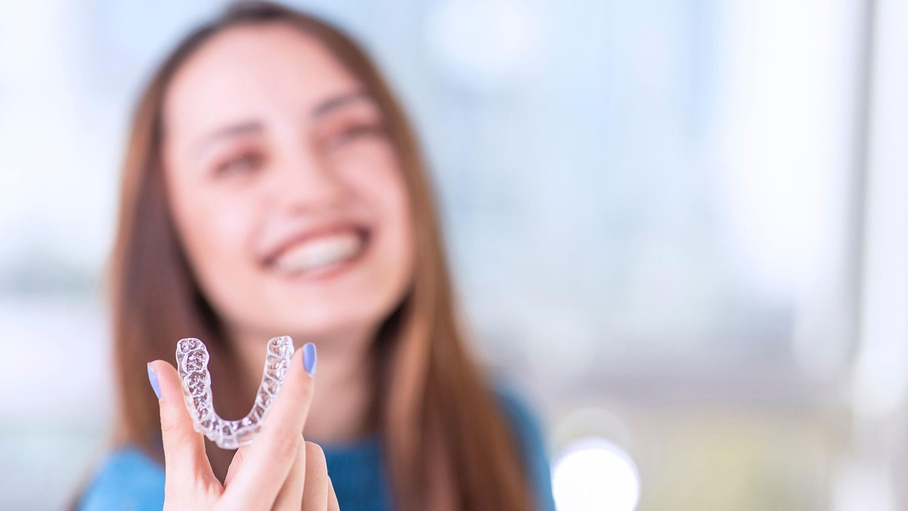 Invisalign Adelaide Dentist: Invisalign clear aligners for discreet teeth straightening. Adelaide Invisalign clear aligners held by a woman for discreet teeth straightening and a confident smile.