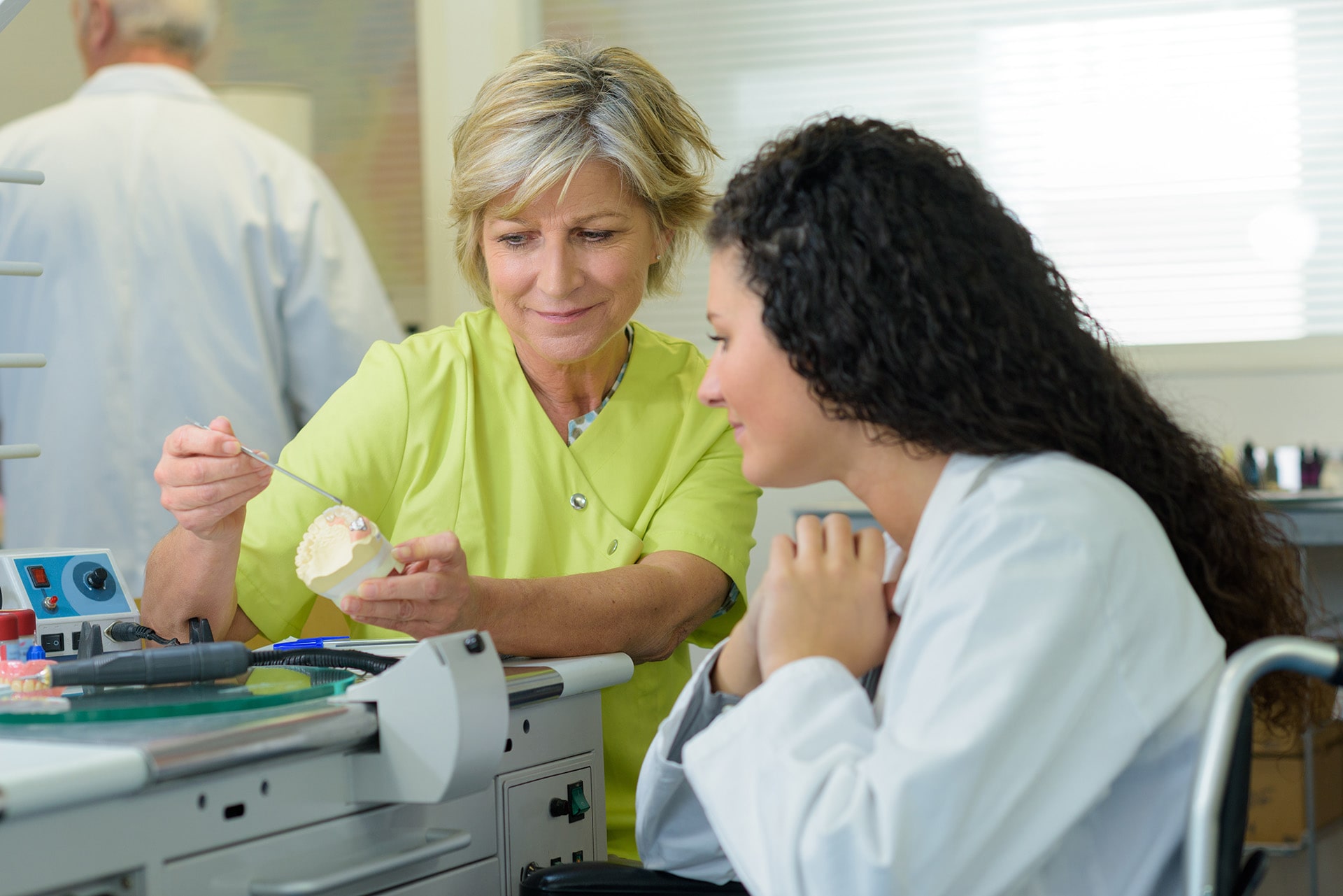 Adelaide dental implants explained by a dentist using a dental implant model for tooth replacement Dentist explaining dental implants Adelaide using a model of teeth and a dental implant procedure